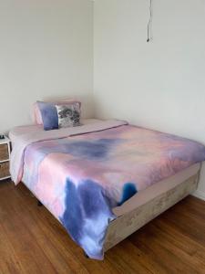 Private Room Near Melbourne Airport في Deer Park: سرير مع بطانية ملونة فوقه