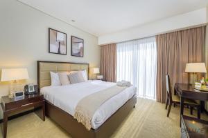 um quarto de hotel com uma cama grande e uma secretária. em Ornate 1BR in The Address Residences Dubai Marina by Deluxe Holiday Homes em Dubai