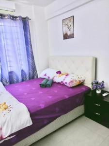 a bed with purple sheets and pillows in a room at Homestay Putrajaya , Icha Homestay Presint 9 in Putrajaya