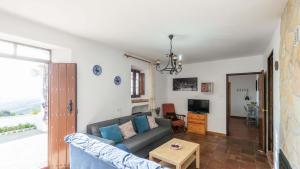 ein Wohnzimmer mit einem Sofa und einem Tisch in der Unterkunft Casa Mina Periana by Ruralidays in Periana