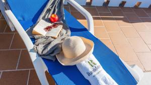 a hat and a book on a blue bench at Casa Mina Periana by Ruralidays in Periana