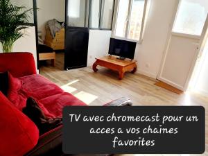- un salon avec un canapé rouge et une télévision dans l'établissement Appartement calme et pratique., à Tours