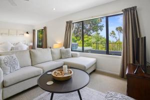 a living room with a couch and a table at Bushside Cottage - Akaroa Holiday Home in Akaroa