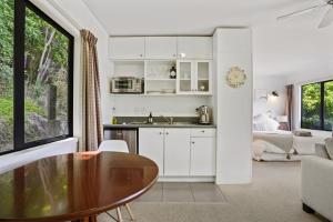 a kitchen and living room with a table and a couch at Bushside Cottage - Akaroa Holiday Home in Akaroa