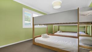 two bunk beds in a room with green walls at Sandy C in Culburra Beach +17 photos
