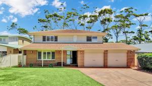 a house with a garage in front of it at Sandy C in Culburra Beach