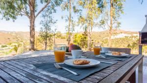 a wooden table with plates of food and glasses of orange juice at Casa Ronda Vélez-Málaga by Ruralidays in Vélez-Málaga