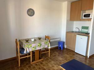 małą kuchnię ze stołem i ściereczką w obiekcie Studio Centre avec Piscine, Balcon et Proximité Plage, 2 Personnes - FR-1-702-3 w Cap d'Agde