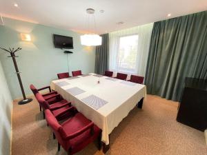 Urgoo hotel في أولان باتور: غرفة طعام مع طاولة بيضاء وكراسي حمراء