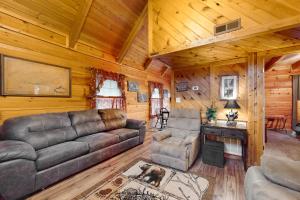 una sala de estar con sofá y sillas en una cabaña en Misty Mountain Cabin en Gatlinburg