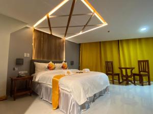 a bedroom with a large bed with yellow curtains at NGN Gran Hotel in Tuguegarao City