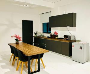 a kitchen with a wooden table and black cabinets at Imperio Armanistay Alor Star in Alor Setar