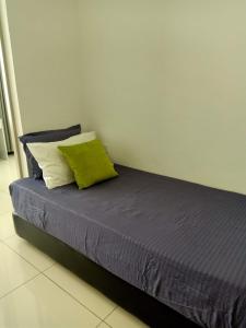 - un lit avec un oreiller vert dans l'établissement BS City Homestay3 - Miri Times Square, à Miri