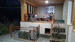 a group of people sitting on a balcony at Hayat Guesthouse Nuratau Mountains in Yukary-Ukhum