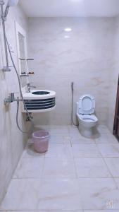 Baño blanco con aseo y lavamanos en غرف الصفا الشهري en Jazán