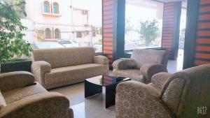 Habitación con sofás, sillas y mesa. en غرف الصفا الشهري, en Jazan