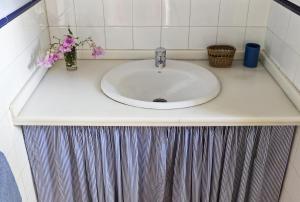 un bancone del bagno con un lavandino con fiori di Cuevas del Pino Turismo Rural y Emocional SL a Villarrubia Altre 46 foto