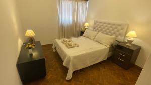 1 dormitorio con 1 cama con 2 mesas y 2 lámparas en Calido en Mendoza