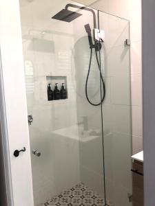 baño con ducha y puerta de cristal en The Stables, en Armidale