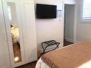 a bedroom with a bed and a flat screen tv on the wall at The Stables in Armidale