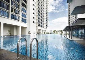 a swimming pool in the middle of a building at Peanut Butter Homestay #Trefoil Setia City in Setia Alam