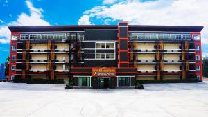 a large building with a sign in front of it at PT Grand Hotel in Ban Tha Makham