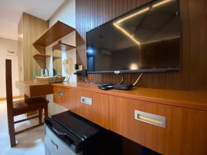 a room with a large television on a wooden cabinet at NGN Gran Hotel in Tuguegarao City