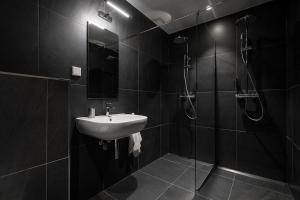タリンにあるW Apartments Kalaranna IIIの黒のバスルーム(シンク、シャワー付)