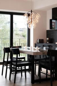 tavolo da pranzo con sedie nere e lampadario pendente di W Apartments Kalaranna III a Tallinn