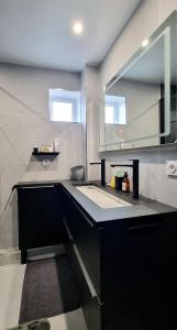a kitchen with a black counter and a sink at Le Perchoir, High-end & Panoramic View in Troyes +5 photos
