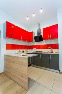 a kitchen with red cabinets and a counter top at Centrum red apartament in Wałbrzych