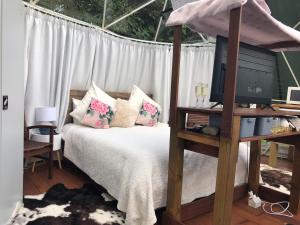 a bedroom with a bed with a tv on it at Flowerhaven - glamping dome in Hamilton