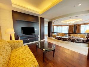 a living room with a couch and a television at Swissôtel Al Murooj Dubai in Dubai