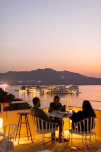 a group of people sitting at a table near the water at Hostel Mantra in Udaipur