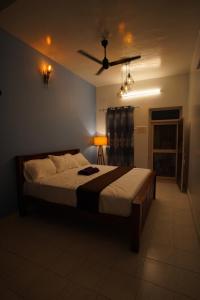 um quarto com uma cama grande e uma ventoinha de tecto em Omkara - The Fives Guest house em Tiruvannamalai