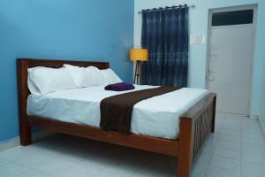 um quarto com uma cama com lençóis brancos e uma janela em Omkara - The Fives Guest house em Tiruvannamalai