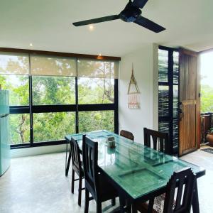 a dining room with a green table and chairs at La Casa de María 11:11 in Chemuyil
