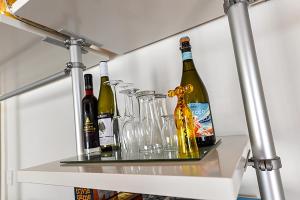 un estante con botellas de vino y vasos. en Galahad's Animal Sanctuary B&B en Gisborne