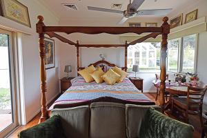 1 dormitorio con cama de madera y almohadas en Galahad's Animal Sanctuary B&B, en Gisborne