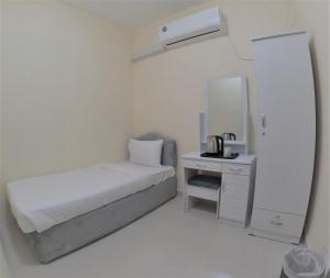 a white bedroom with a bed and a mirror at Hor Al Anz Star Residence - Home Stay in Dubai