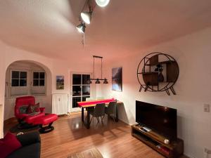 - un salon avec une table rouge et une télévision dans l'établissement FeWo Lotti, à Berchtesgaden