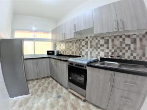 een keuken met een wastafel en een fornuis top oven bij Hor Al Anz Star Residence - Home Stay in Dubai