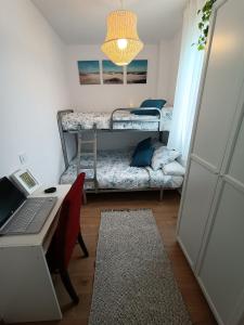 Habitación con escritorio, ordenador portátil y cama en Precioso apartamento con piscina en la playa, en Mogro