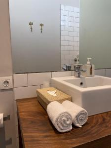a bathroom with a sink and towels on a wooden counter at Bloomfield Umalas in Canggu