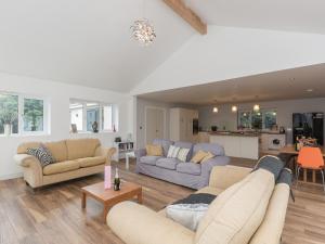 sala de estar con 2 sofás y cocina en Lavender Lea, en Henley-in-Arden