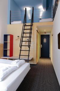 a staircase in a room with a bed and a hallway at Maverick Budapest Soho in Budapest