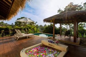 a backyard with a pool and a garden with a tub of flowers at Elixir Koh Yao Yai - SHA Plus in Ko Yao Yai