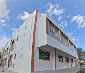 a white building with red accents on the side at Hor Al Anz Star Residence - Home Stay in Dubai