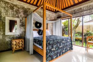 sypialnia z łóżkiem z baldachimem w obiekcie Villa Elysium Fields - Rustic Meets Industrial Chic Design w mieście Canggu