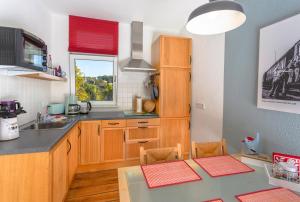 a kitchen with wooden cabinets and a table with chairs at Bahnhof Droyßig - Übernachten im Denkmal in Droyßig